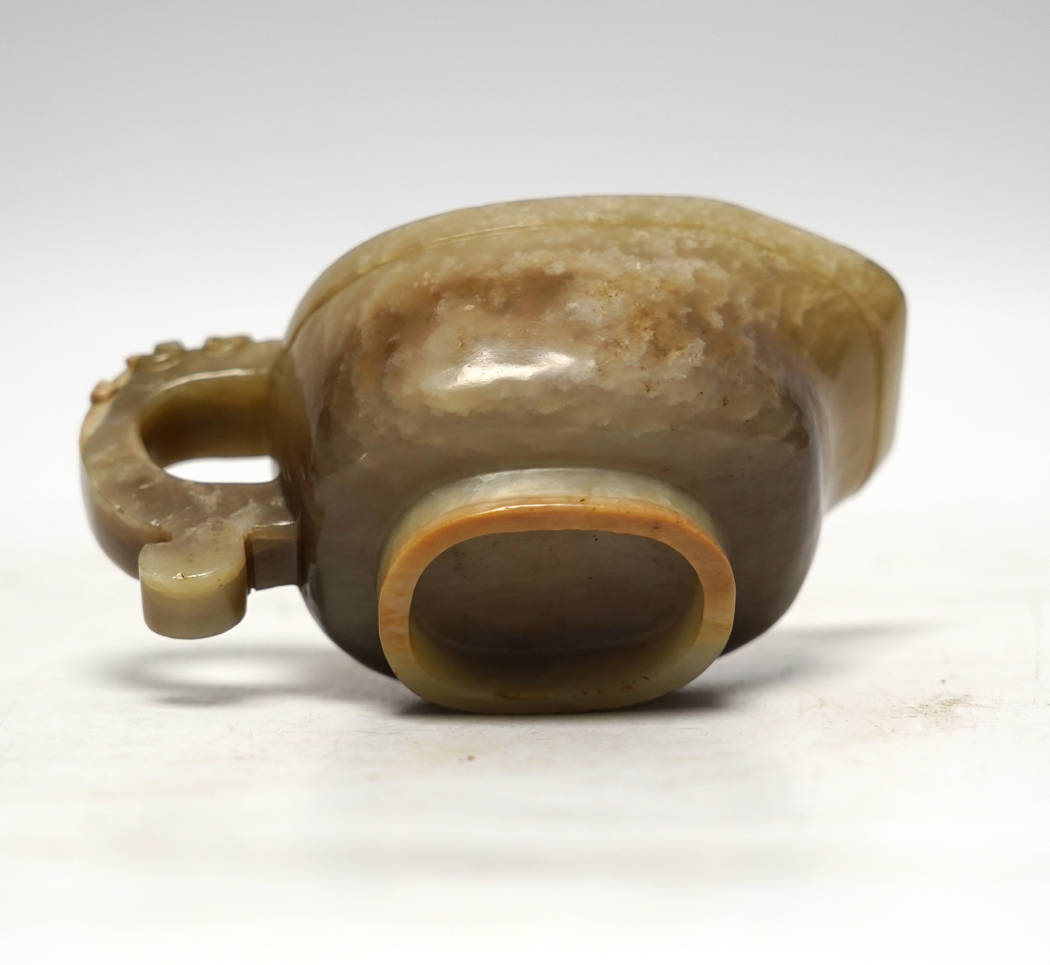 An 18th century Chinese archaistic jade pouring vessel, yi, with carved dragon handle, 6cm high, on a hardwood stand